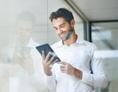 A man smiling while looking at his phone